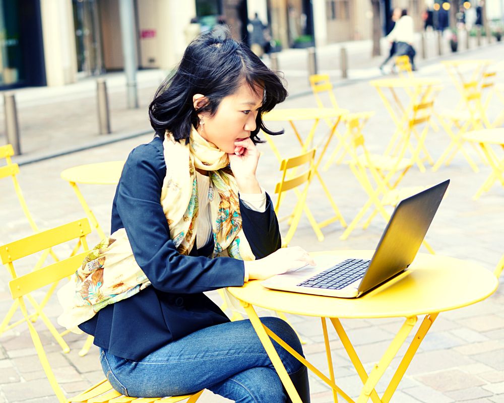 A girl sitting on a chair working on the laptop